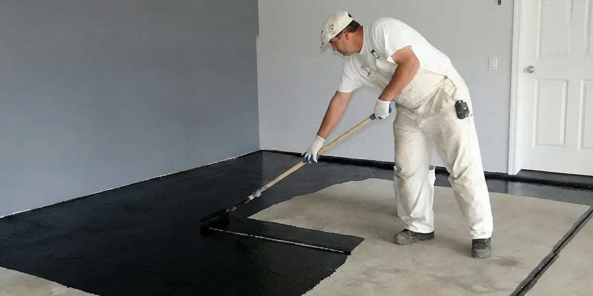 basement waterproofing professional applying waterproof coating to protect a basement floor in Albany, NY